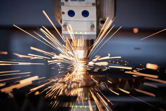 Close-up of a high-powered laser engraving serial numbers and barcodes onto an anodized aluminum aerospace component